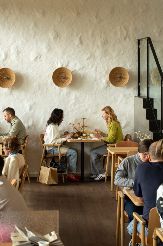 Manhã no Nai Cascais: sala clara com mesas de madeira e luz natural